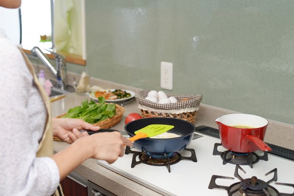 キッチンで料理する女性